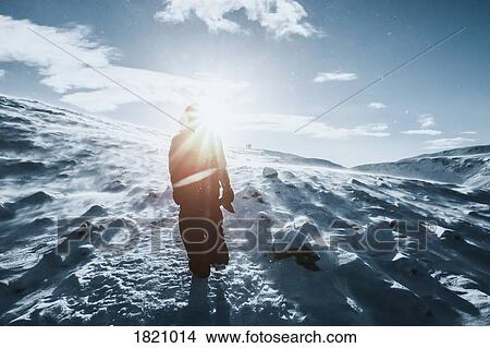 Man walking along sunny snow covered landscape, Reykjadalur, Iceland View Large Photo Image Picture - Man walking along sunny snow covered landscape, Reykjadalur, Iceland. Fotosearch