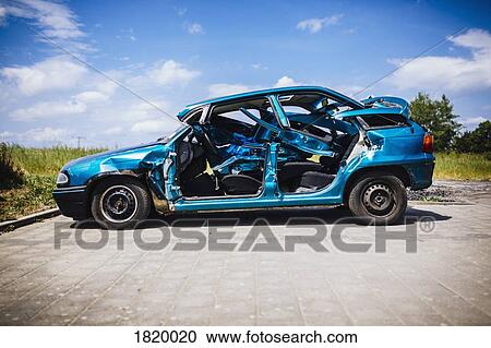 Stock Image - Mangled blue car in sunny parking lot. Fotosearch