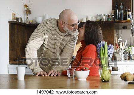 Mature couple by table at home View Large Photo Image Stock Image - Mature couple by table at home. Fotosearch