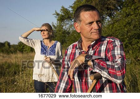 Mature couple working at farm on sunny day View Large Photo Image Stock Photo - Mature couple working at farm on sunny day. Fotosearch