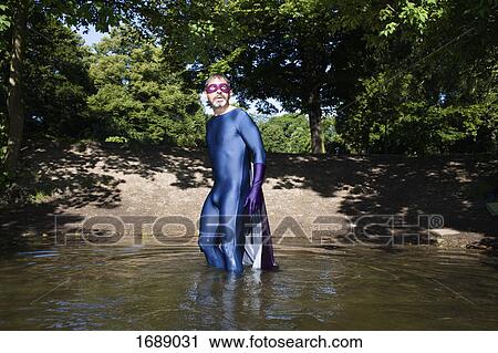 Mature superhero standing in river against trees View Large Photo Image Stock Image - Mature superhero standing in river against trees. Fotosearch