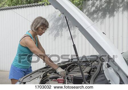 Mature woman repairing breakdown car View Large Photo Image Stock Image - Mature woman repairing breakdown car. Fotosearch