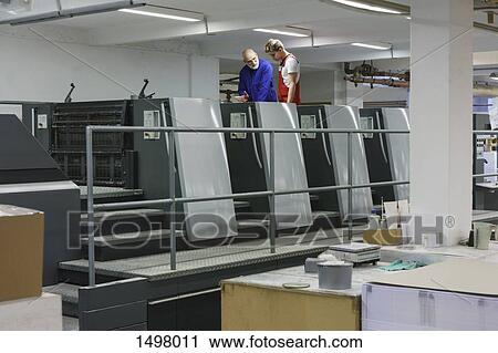 Mature worker talking with colleague at equipment in printing press View Large Photo Image Stock Image - Mature worker talking with colleague at equipment in printing press. Fotosearch