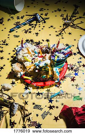 Messy birthday cake and confetti on yellow background View Large Photo Image Stock Photo - Messy birthday cake and confetti on yellow background. Fotosearch