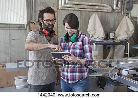 Mid adult carpenters discussing over digital tablet in workshop View Large Photo Image Stock Image - Mid adult carpenters discussing over digital tablet in workshop. Fotosearch