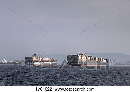 Mid distant view of container ships moored on sea against sky View Large Photo Image Stock Image - Mid distant view of container ships moored on sea against sky. Fotosearch