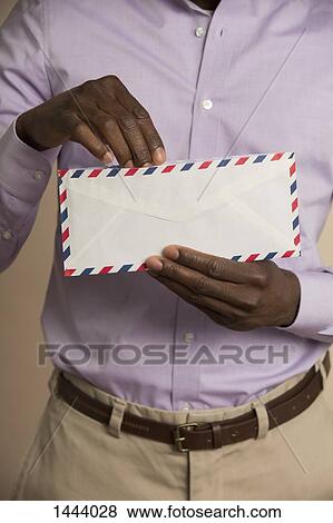 Stock Photo - Midsection of man holding envelope. Fotosearch