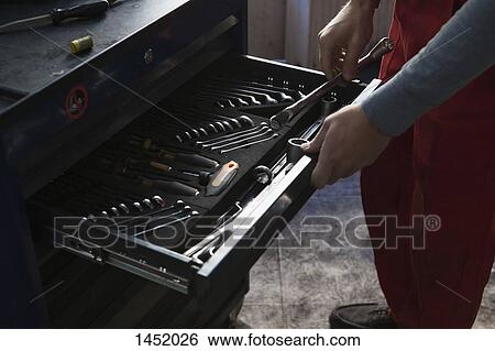Midsection of mechanic removing tools from drawer at garage View Large Photo Image Stock Photograph - Midsection of mechanic removing tools from drawer at garage. Fotosearch