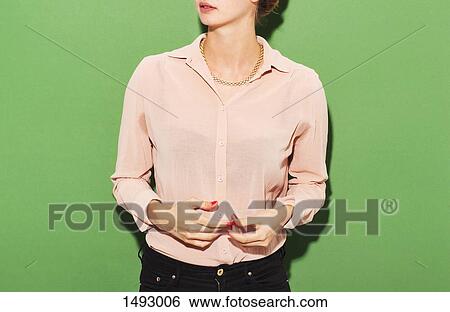 Midsection of woman in smart casuals standing against green background View Large Photo Image Stock Photograph - Midsection of woman in smart casuals standing against green background. Fotosearch