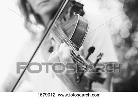 Stock Image - Midsection of woman playing violin. Fotosearch