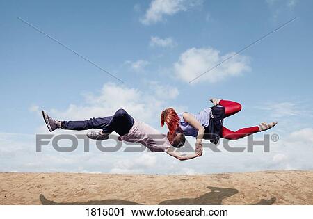 Modern aerialist dancers performing, flying over beach View Large Photo Image Stock Image - Modern aerialist dancers performing, flying over beach. Fotosearch