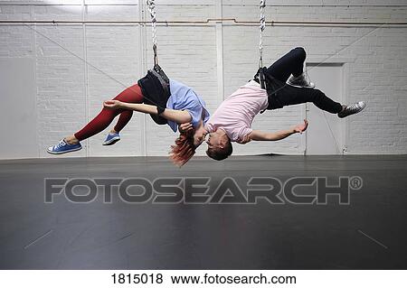 Stock Photo - Modern aerialist dancers performing, hanging upside-down. Fotosearch
