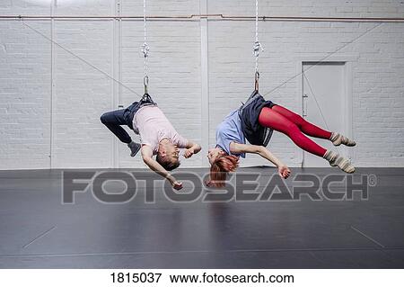Stock Photo - Modern aerialist dancers performing, hanging upside-down. Fotosearch