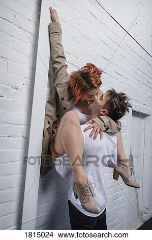 Picture - Modern dancers kissing against white brick wall. Fotosearch