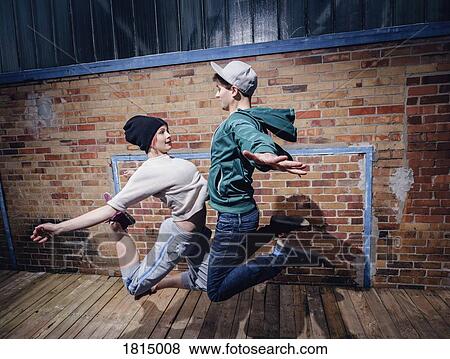 Modern dancers performing against brick wall View Large Photo Image Stock Photo - Modern dancers performing against brick wall. Fotosearch