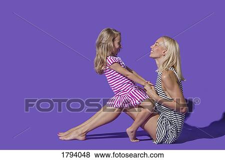 Mother and daughter in striped dresses on purple background View Large Photo Image Stock Photo - Mother and daughter in striped dresses on purple background. Fotosearch
