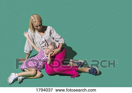 Mother and daughter talking against green background View Large Photo Image Stock Photo - Mother and daughter talking against green background. Fotosearch