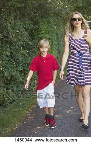 Mother and son walking on street View Large Photo Image Picture - Mother and son walking on street. Fotosearch