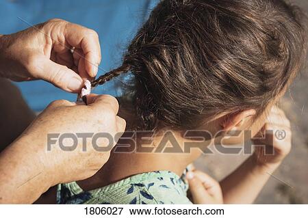 Mother braiding daughters hair View Large Photo Image Stock Photo - Mother braiding daughters hair. Fotosearch