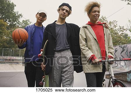 Multi-ethnic friends walking together at park View Large Photo Image Stock Photography - Multi-ethnic friends walking together at park. Fotosearch