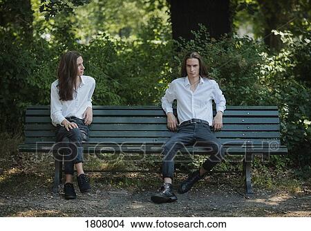 Multiple image man sitting on park bench with legs crossed and legs apart View Large Photo Image Picture - Multiple image man sitting on park bench with legs crossed and legs apart. Fotosearch