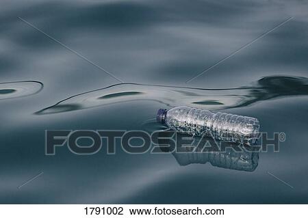 Plastic water bottle floating on water surface View Large Photo Image Stock Image - Plastic water bottle floating on water surface. Fotosearch