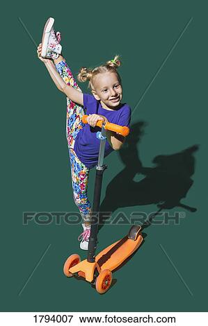 Playful girl with scooter doing standing splits on green background View Large Photo Image Stock Photo - Playful girl with scooter doing standing splits on green background. Fotosearch