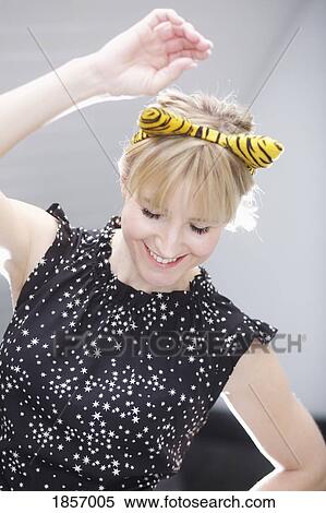Stock Photography - Playful woman in cat costume ears dancing. Fotosearch