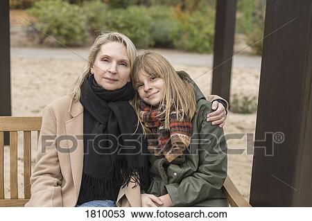Portrait affectionate mother and daughter hugging on park bench View Large Photo Image Stock Image - Portrait affectionate mother and daughter hugging on park bench. Fotosearch
