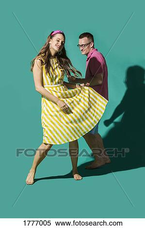 Portrait carefree couple dancing against turquoise background View Large Photo Image Stock Photography - Portrait carefree couple dancing against turquoise background. Fotosearch