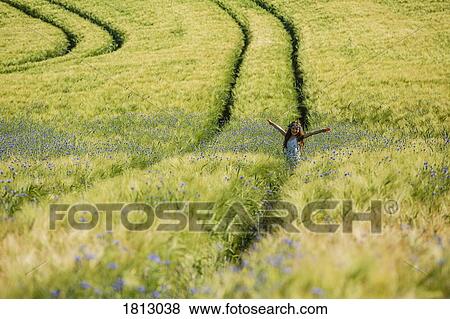 Portrait carefree girl with arms outstretched in sunny, idyllic rural field with wildflowers View Large Photo Image Stock Photo - Portrait carefree girl with arms outstretched in sunny, idyllic rural field with wildflowers. Fotosearch