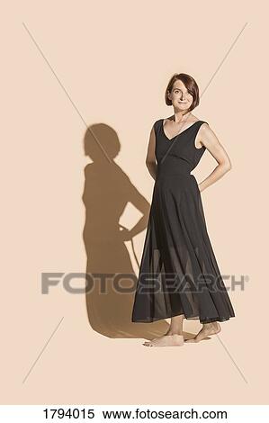 Portrait confident, barefoot woman in black dress View Large Photo Image Stock Photography - Portrait confident, barefoot woman in black dress. Fotosearch