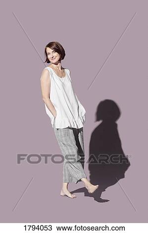 Portrait confident, barefoot woman against purple background View Large Photo Image Stock Image - Portrait confident, barefoot woman against purple background. Fotosearch