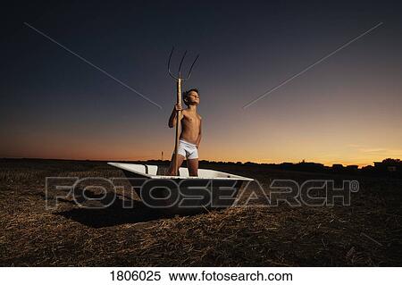Portrait confident boy in underwear holding pitchfork in bathtub in rural field View Large Photo Image Stock Photography - Portrait confident boy in underwear holding pitchfork in bathtub in rural field. Fotosearch