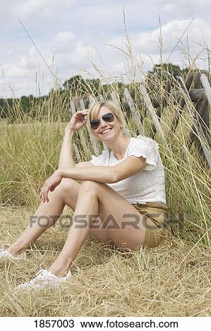 Portrait confident, carefree woman sitting in tall grass View Large Photo Image Stock Image - Portrait confident, carefree woman sitting in tall grass. Fotosearch