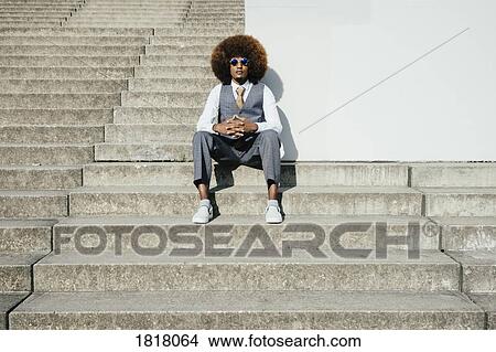 Portrait confident, cool, well-dressed young man with afro sitting on urban steps View Large Photo Image Picture - Portrait confident, cool, well-dressed young man with afro sitting on urban steps. Fotosearch