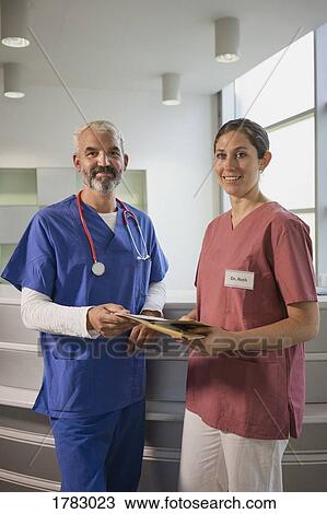 Portrait confident doctors with medical record in hospital View Large Photo Image Stock Image - Portrait confident doctors with medical record in hospital. Fotosearch