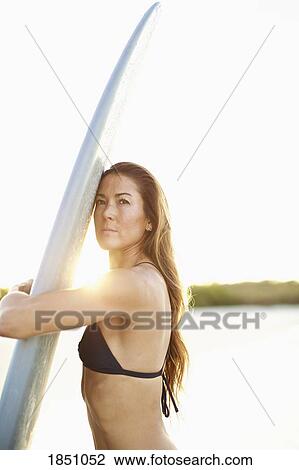 Portrait confident female surfer hugging surfboard View Large Photo Image Stock Image - Portrait confident female surfer hugging surfboard. Fotosearch