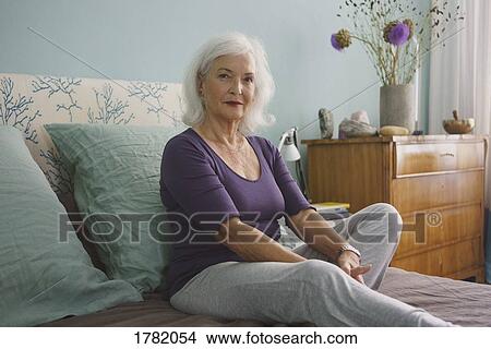 Portrait confident senior woman relaxing on bed View Large Photo Image Picture - Portrait confident senior woman relaxing on bed. Fotosearch