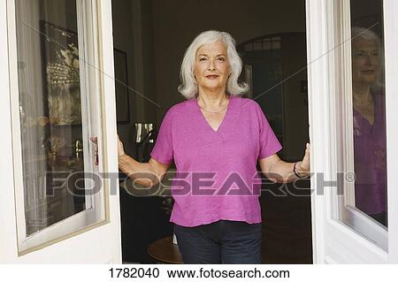 Portrait confident senior woman standing in patio doorway View Large Photo Image Stock Image - Portrait confident senior woman standing in patio doorway. Fotosearch