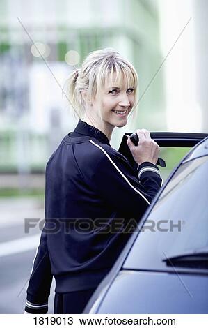 Portrait confident woman getting into car View Large Photo Image Stock Image - Portrait confident woman getting into car. Fotosearch