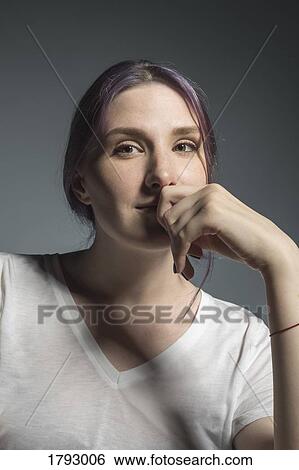 Stock Photograph - Portrait confident young woman against gray background. Fotosearch