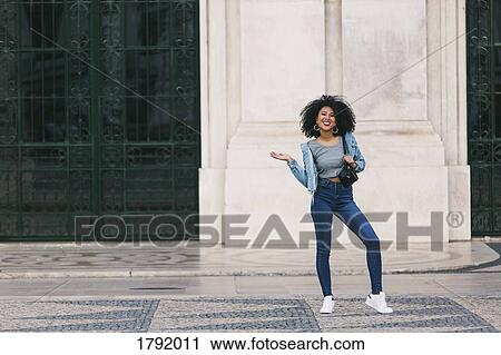 Stock Image - Portrait confident young woman in town square. Fotosearch