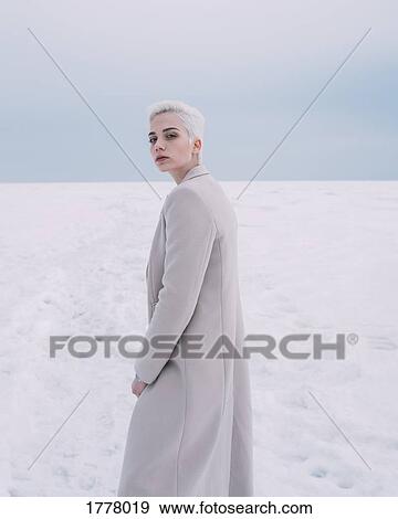 Portrait confident young woman walking in snow View Large Photo Image Stock Photo - Portrait confident young woman walking in snow. Fotosearch