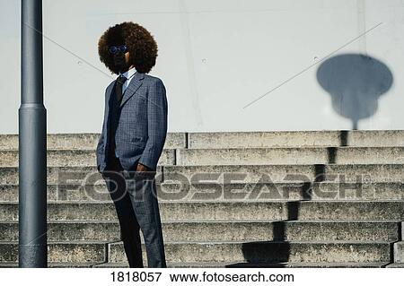Stock Photo - Portrait cool, well dressed young man with afro at urban steps. Fotosearch