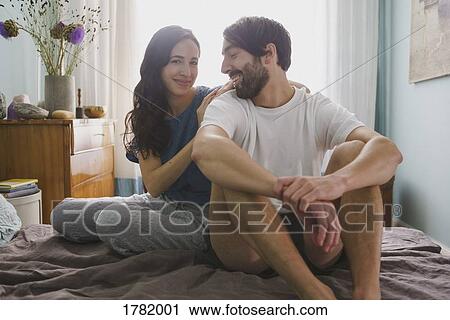 Stock Image - Portrait couple relaxing on bed. Fotosearch