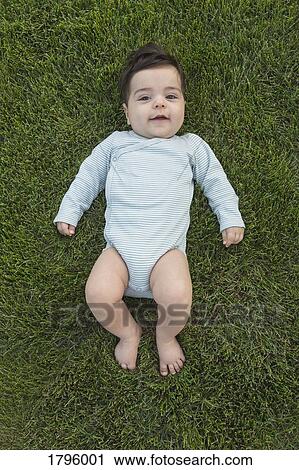 Portrait cute baby boy laying in grass View Large Photo Image Stock Image - Portrait cute baby boy laying in grass. Fotosearch