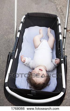 Stock Photograph - Portrait cute baby in stroller. Fotosearch