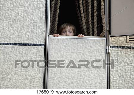 Portrait cute, curious girl peeking from behind trailer door View Large Photo Image Stock Photo - Portrait cute, curious girl peeking from behind trailer door. Fotosearch