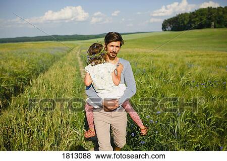 Portrait father carrying daughter in sunny, idyllic rural field View Large Photo Image Stock Photo - Portrait father carrying daughter in sunny, idyllic rural field. Fotosearch